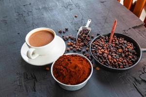 Roasted coffee beans with coffee powder and coffee cups. photo