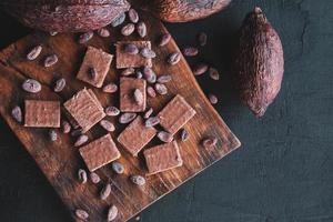 Granos de chocolate y cacao con cacao sobre un fondo negro foto