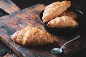 Desayuno croissant pan en la mesa de madera foto