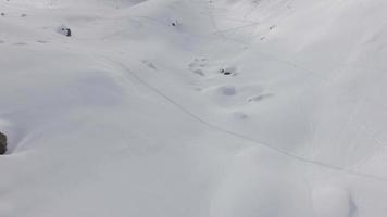 vista aérea de los esquiadores en montañas cubiertas de nieve. video