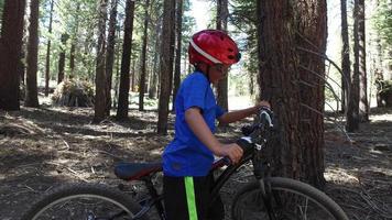 en pojke åker sin mountainbike på en singletrack-smutspår i skogen.