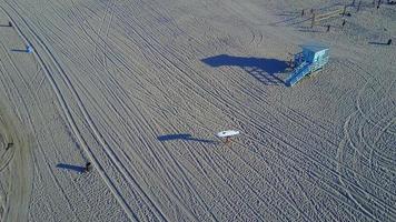 Aerial drone uav view of a surfer walking with his sup surfboard.