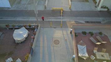 Vista aérea de uav drone de un niño jugando al fútbol en una calle peatonal en un vecindario.