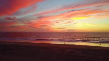 Luftdrohnenansicht eines Sonnenuntergangs am Strand über dem Ozean. video