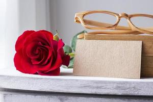 Rosa roja y papel marrón en blanco sobre gabinete vintage foto