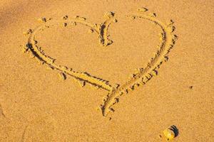 Heart drawn in the sand. Beach background. Top view photo