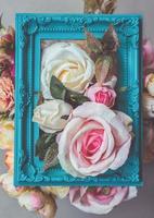 composición hecha de marco de fotos y flores artificiales en colores pastel