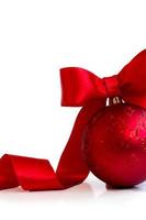 Red christmas ball, with red ribbon and bow, on white background with copy space