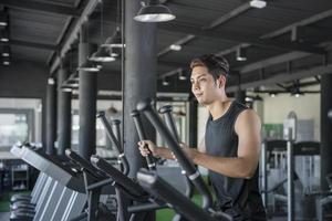 Handsome man running on a treadmill in a gym photo