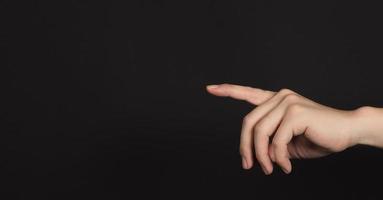 Index finger pointing and isolated on black background photo