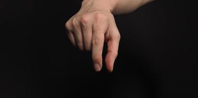 Man's hand in a holding gesture isolated on black background photo