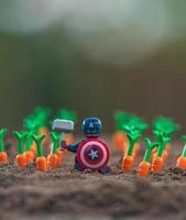 varsovia 2020 - lego superhéroe minifigura avenger capitán américa en el campo de las zanahorias foto