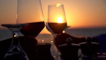 un hombre y una mujer cenan y beben vino en la playa de una isla tropical. video