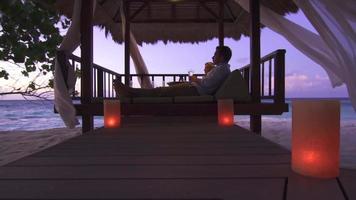 um casal bebendo champanhe na praia de um hotel resort em uma ilha tropical. video