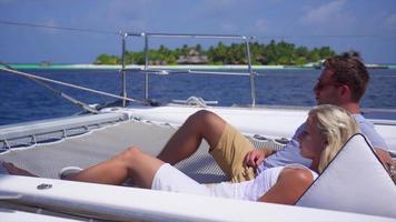 una pareja relajándose en un barco en un hotel resort de una isla tropical.