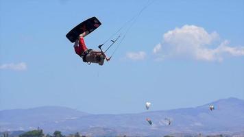 een man kiteboarden en een springtruc doen op een kiteboard. video