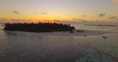 vista aérea de drone de una pintoresca isla tropical en las maldivas al atardecer. video