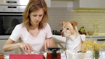 Woman with a dog in the kitchen at the table Breakfast Friendship of man and pet