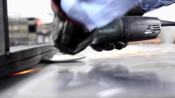un hombre puliendo acero para crear una estructura en un taller mecánico. video