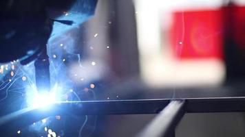 un hombre soldando barras de acero juntas para crear una estructura en un taller mecánico. video