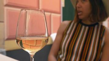 una donna beve vino quando viaggia in una località turistica di lusso in italia, europa. video