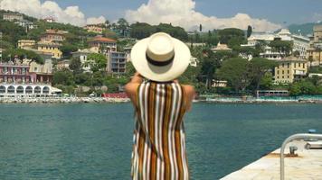 eine frau mit hut fotografiert während ihrer reise in einen luxus-resort in italien, europa. video