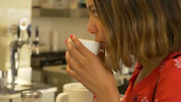 una donna in viaggio beve caffè cappuccino espresso in un bar.