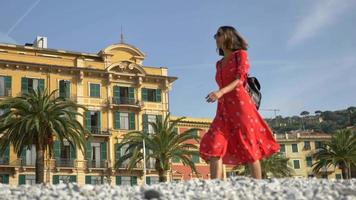 eine frau, die in einem roten kleid in einem luxus-resort in italien, europa, spaziert.