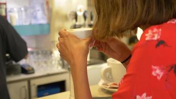 une femme voyageant boit du café cappuccino expresso dans un café.