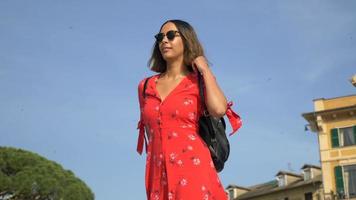 en kvinna som går i en röd klänning i en lyxig semesterort i Italien, Europa.