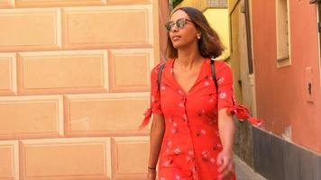 en kvinna som går i en röd klänning i en lyxig semesterort i Italien, Europa.