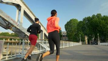 ett par som springer över en bro. video
