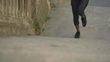 närbild av ben på en kvinna som kör på trappor i en stad för ett träningspass.
