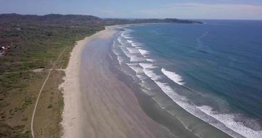 Luftdrohnenansicht des Strandes, der Felsen und der Gezeitenpools in Guiones, Nosara, Costa Rica. video