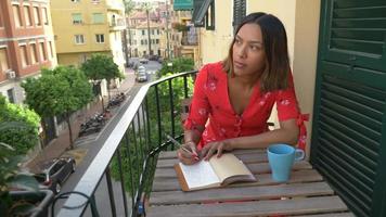 A woman writing in a journal diary traveling in a luxury resort town in Italy, Europe. video