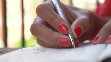 Close-up of a woman writing in a journal diary traveling in a luxury resort town in Italy, Europe. video