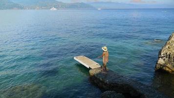 A woman traveling alone on a dock over the Mediterranean Sea in Italy, Europe. video