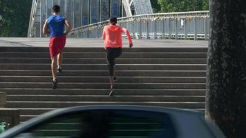 ett par som kör på trappor i en stad som ett träningspass.