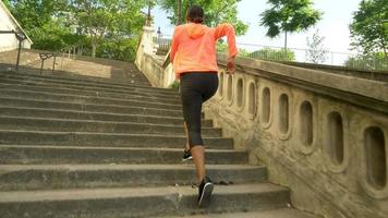 närbild av ben på en kvinna som kör på trappor i en stad för ett träningspass.