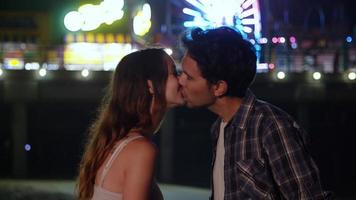 Portrait of young couple kissing at night with lights in background photo