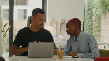 Young man and woman using laptop in office photo