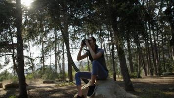 Portrait of woman taking photo with camera in forest