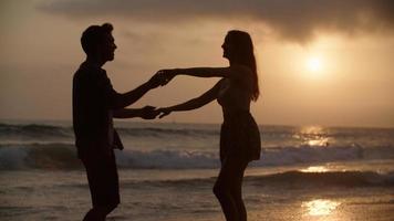 Portrait of young couple dancing on beach photo