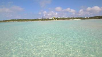 Vista aérea de drone de agua clara y casas en una playa y costa de una isla tropical en las bahamas, caribe.