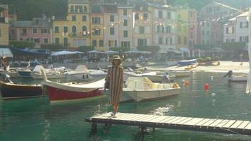 een vrouw op een aanlegsteiger in portofino, italië, een luxe vakantieoord in europa. video