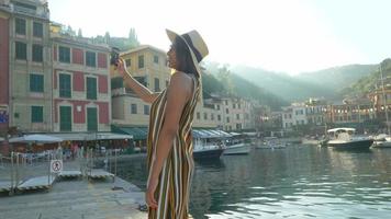una mujer se toma selfies y usa videollamadas facetime en una ciudad turística de lujo en Europa. video