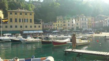 una mujer en un muelle en Portofino, Italia, una ciudad turística de lujo en Europa. video