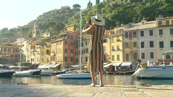 una mujer que toma fotografías con su teléfono móvil mientras viaja en portofino, italia. video