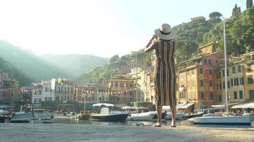 una mujer que toma fotografías con su teléfono móvil mientras viaja en portofino, italia. video