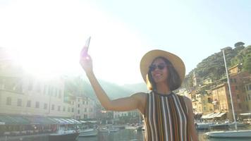 una mujer se toma selfies y usa videollamadas facetime en una ciudad turística de lujo en Europa. video